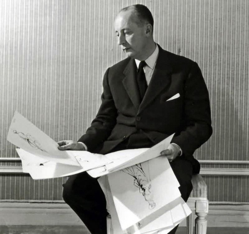 Christian Dior with sketches of dress models, photo