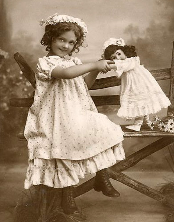 Girl playing with a doll - vintage photo